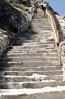 Ein Mensch steigt eine steile Steintreppe hinauf